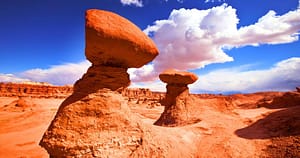 red stone rock formations, blue sky with clouds